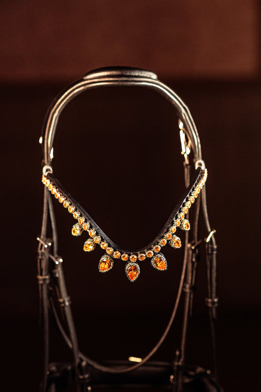 Horse browband Triumph Grandé Topaz by IBV Equine
Presenting The Triumph Collection: A Tiara Worthy of Royalty.
Prepare to be captivated. This is the magnificent "big brother" to our Triumph collection, designed for unparalleled impact and ensuring it attracts attention from all corners of the arena. The commanding top row of 10mm K9 crystals is held securely by "clawed paws" that literally embrace each dazzling rhinestone, maximizing their brilliance and creating a continuous river of light. Below, each in