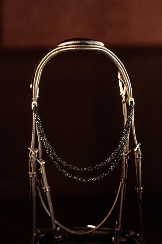 Horse browband Spectrum Double White by IBV Equine
Experience a new dimension of browband design. Crafted with a pair of soft,
flexible tubes, each generously sprinkled with dazzling rhinestones, this piece offers a unique texture and radiant sparkle. An internal metal wire allows for effortless shaping, ensuring a perfect contour to your horse's brow and maintaining its elegant form.
Each browband is handmade from scratch using premium European materials and&nbsp;durable leather. Featuring our exclusive ma