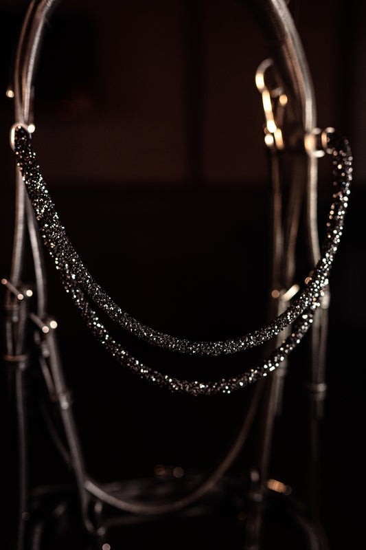 Horse browband Spectrum Double White by IBV Equine
Experience a new dimension of browband design. Crafted with a pair of soft,
flexible tubes, each generously sprinkled with dazzling rhinestones, this piece offers a unique texture and radiant sparkle. An internal metal wire allows for effortless shaping, ensuring a perfect contour to your horse's brow and maintaining its elegant form.
Each browband is handmade from scratch using premium European materials and&nbsp;durable leather. Featuring our exclusive ma