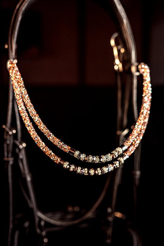 Horse browband Spectrum Double Topaz with beads browband  by IBV Equine
Experience a new dimension of browband design. Crafted with a pair of soft,
flexible tubes, each generously sprinkled with dazzling rhinestones, this piece offers a unique texture and radiant sparkle. An internal metal wire allows for effortless shaping, ensuring a perfect contour to your horse's brow and maintaining its elegant form.
Each browband is handmade from scratch using premium European materials and&nbsp;durable leather. Featu